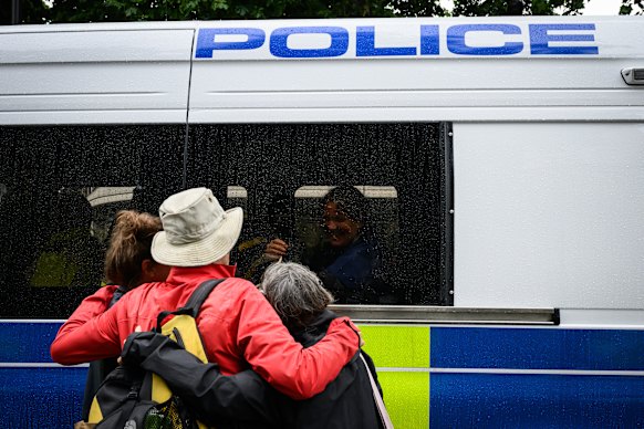 Een voorstander van verboden groep Palestine Action lacht naar vrienden nadat hij is gearresteerd.