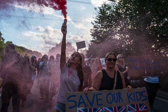 Een vrouw houdt een bord vast tijdens een protest buiten het Bell Hotel in Epping, Engeland.