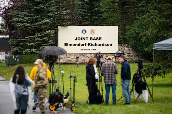 Leden van de media verzamelen zich bij de ingang van de luchtbasis in Anchorage de dag voor de top.