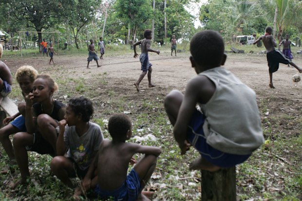 Jongeren die voetballen in de villiade van Kakabona, net buiten Honiara.