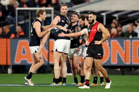 Francis Evans van de Blues wordt gefeliciteerd door teamgenoten na het schoppen van een doelpunt.