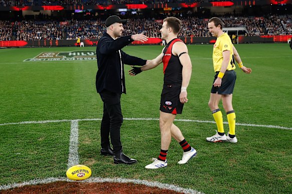Zach Merrett van de Bombers wordt omarmd door broeder Jackson vóór zijn 250e wedstrijd.