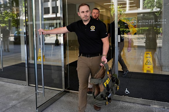 FBI-agenten lopen de vooringang van ex-Trump nationale veiligheidsadviseur John Bolton's Washington-kantoor.