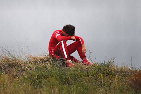 Charles Leclerc kijkt naar de race nadat hij zijn Ferrari heeft teruggetrokken.