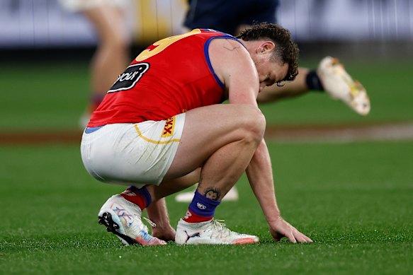 Lachie Neale zakt op de grond na een kuitblessure. 