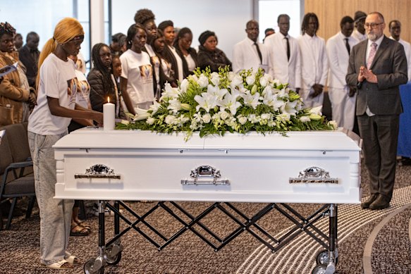 Rouwenden betuigen hun respect aan een jongen die veel te jong stierf.