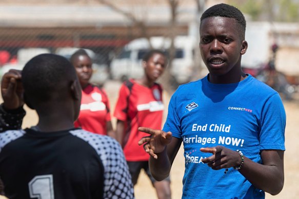 Een voetbalcoach spreekt met meisjes tijdens het toernooi.