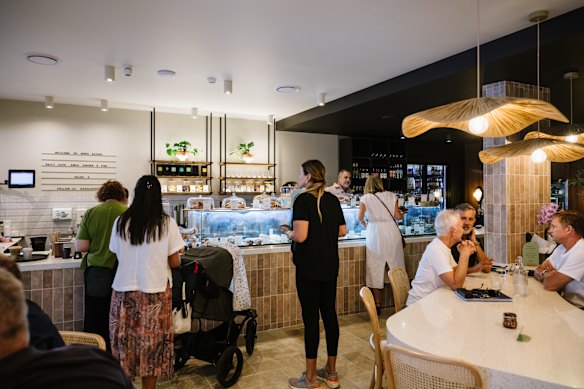 Een mooie gebogen gemeenschappelijke tafel is het middelpunt van het nieuwe café.