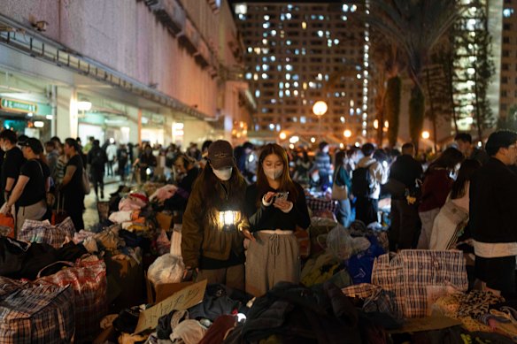 Vrijwilligers zorgen voor kleding en benodigdheden voor de overlevende bewoners in de nasleep van de dodelijke brand.